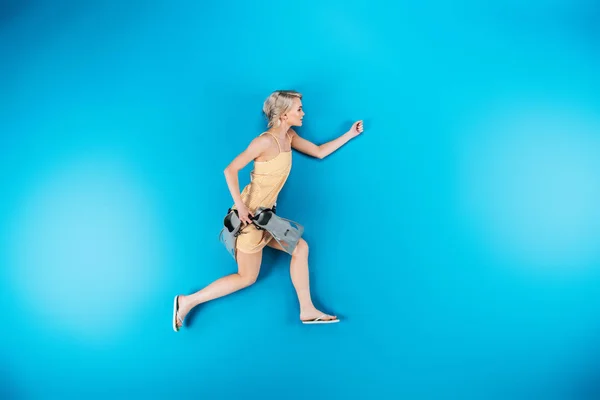 Ganzkörperansicht der schönen jungen Frau in Flip-Flops mit Schwimmflossen und wegschauen auf blau — Stockfoto