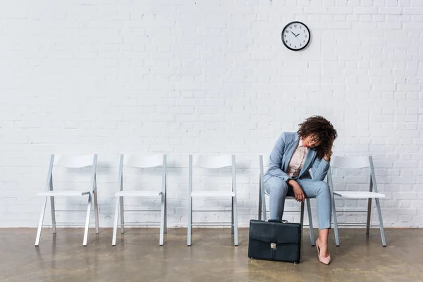 Втомлена жінка-кандидат з портфелем чекає на співбесіду — стокове фото