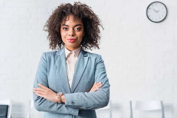 Attractive african american businesswoman standing with folded arms — Stock Photo