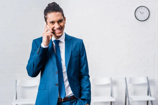 Молодий усміхнений бізнесмен розмовляє по телефону — стокове фото