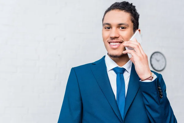 Молодий усміхнений бізнесмен розмовляє по телефону — стокове фото