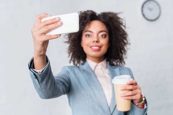 Geschäftsfrau im Anzug hält Kaffeetasse und macht Selfie — Stockfoto