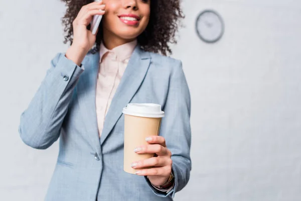 Junge Geschäftsfrau mit Kaffeetasse telefoniert — Stockfoto