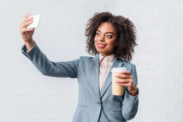 Giovane donna d'affari con tazza di caffè scattare selfie — Foto stock