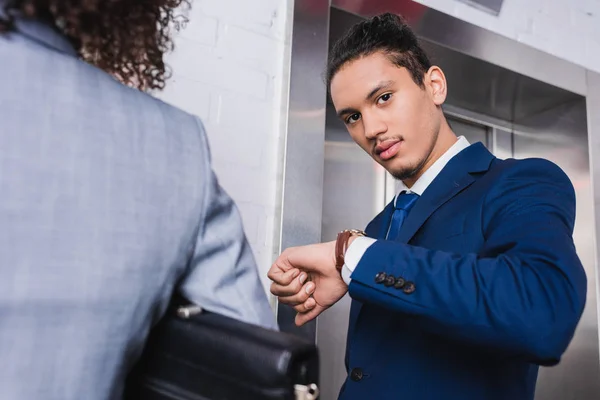 Uomo d'affari controlla il suo orologio e in attesa di ascensore — Foto stock