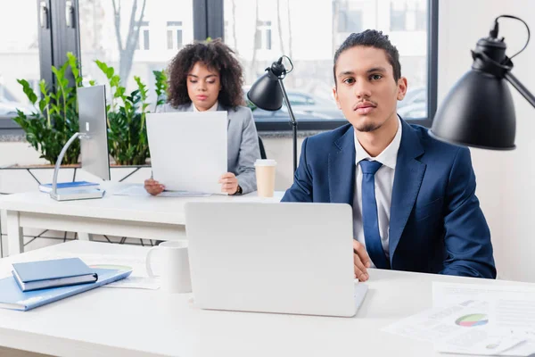 Empresario y empresaria afroamericana que trabaja con computadoras en oficina ligera - foto de stock