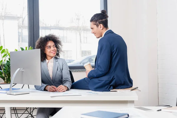 Femme par ordinateur et homme avec tasse de café discuter projet d'entreprise — Photo de stock