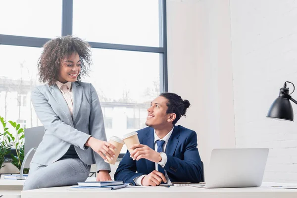 African american businesspeople toasting with paper cups at workplace — Stock Photo