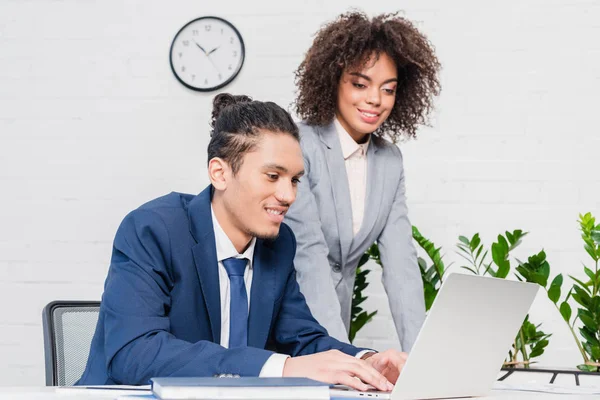 Geschäftsfrau sieht Mann im Büro am Laptop arbeiten — Stockfoto