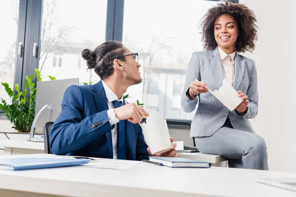 Business colleagues eating chinese takeaway food during lunch in office — Stock Photo