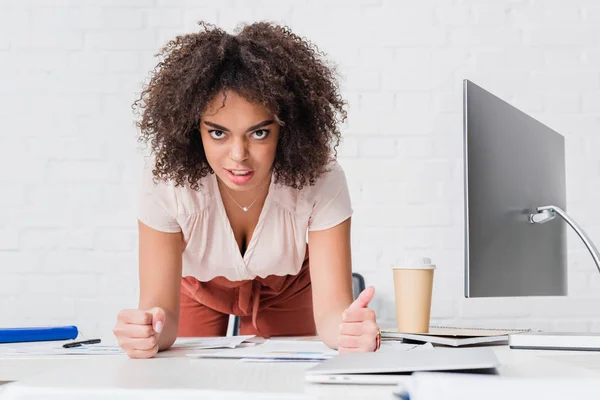 Donna d'affari arrabbiata appoggiata sul tavolo con il computer in ufficio — Foto stock