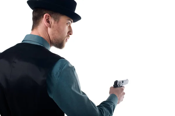 Вид сзади шпиона в шляпе с пистолетом в руке, изолированный на белом — стоковое фото