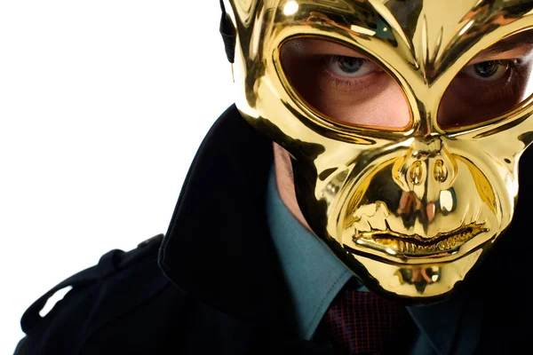 Retrato de criminal en máscara dorada y abrigo negro mirando a la cámara aislada en blanco - foto de stock