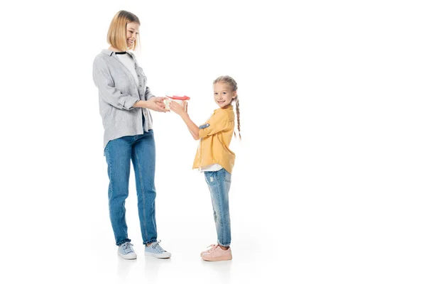 Маленька дочка дає загорнутий подарунок матері ізольовано на білому, концепція святкового дня матері — стокове фото