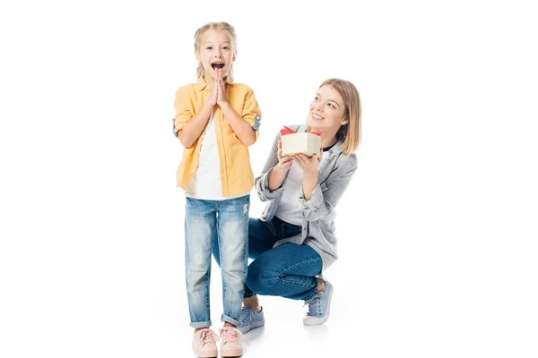 Mother with wrapped gift greeting excited daughter isolated on white — Stock Photo