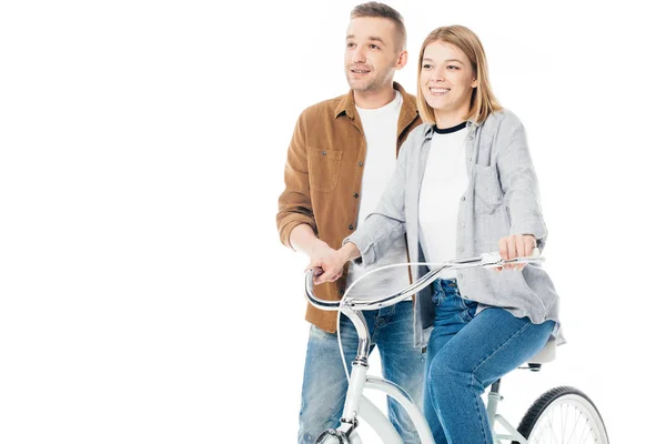 Sonriente hombre y esposa en bicicleta mirando hacia otro lado aislado en blanco - foto de stock