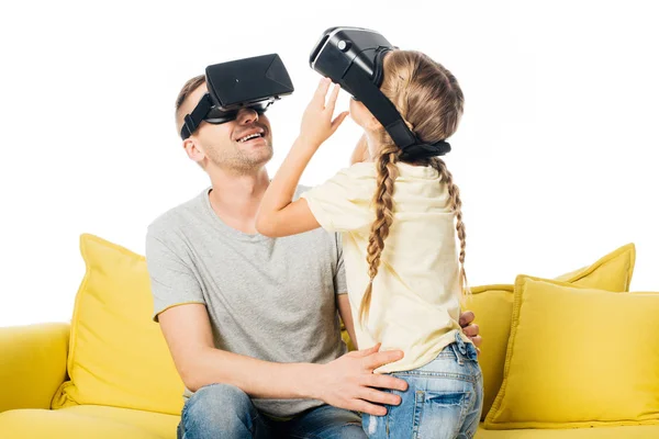 Батько і дочка у гарнітурах віртуальної реальності на жовтому дивані ізольовані на білому — стокове фото