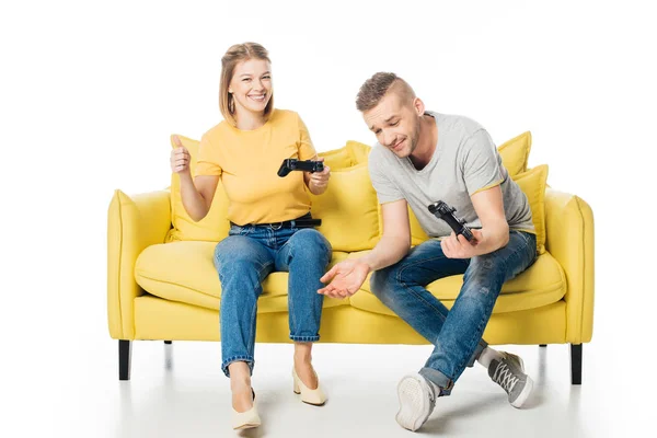 Пара на жовтому дивані грає в відеогру разом ізольовано на білому — стокове фото