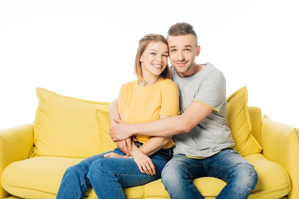 Porträt eines glücklichen Paares auf gelbem Sofa isoliert auf weiß — Stockfoto