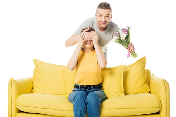 Homme avec bouquet de tulipes couvrant les yeux des femmes pour la surprendre isolée sur blanc — Photo de stock