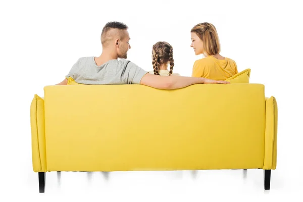Vue arrière des parents et de la fille assis sur un canapé jaune isolé sur blanc — Photo de stock
