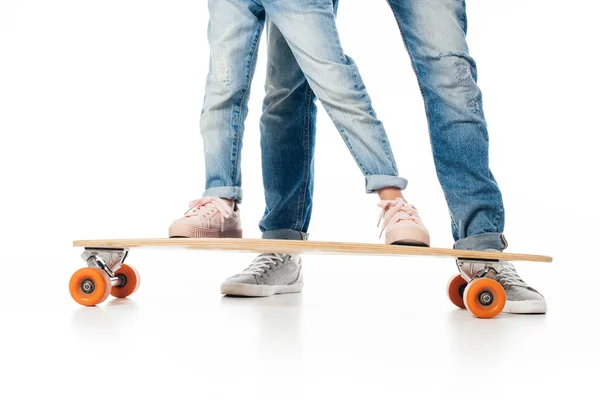Обрезанный снимок отца и дочери на скейтборде, изолированный на белом — стоковое фото