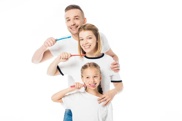 Portrait of family in similar clothing with toothbrushes isolated on white — Stock Photo