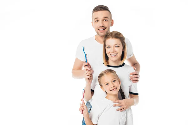 Portrait of cheerful family in similar clothing with toothbrushes isolated on white — Stock Photo
