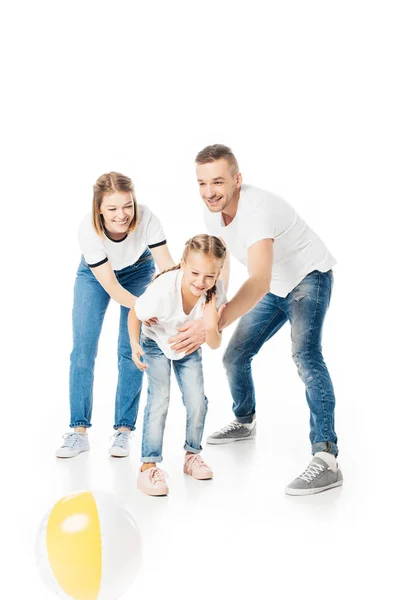 Parents and kid in similar clothing playing with ball isolated on white — Stock Photo