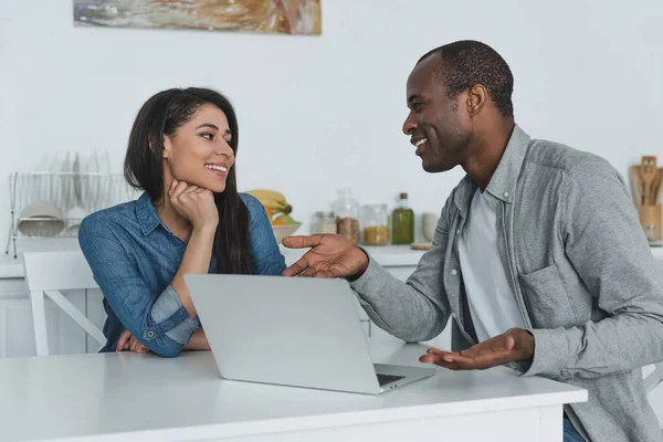 African american girlfriend and boyfriend using laptop in kitchen — Stock Photo