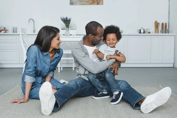 Genitori afro-americani divertirsi con il figlio sul pavimento a casa — Foto stock