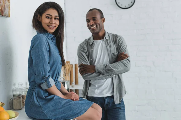 Smiling african american girlfriend and boyfriend at kitchen — Stock Photo