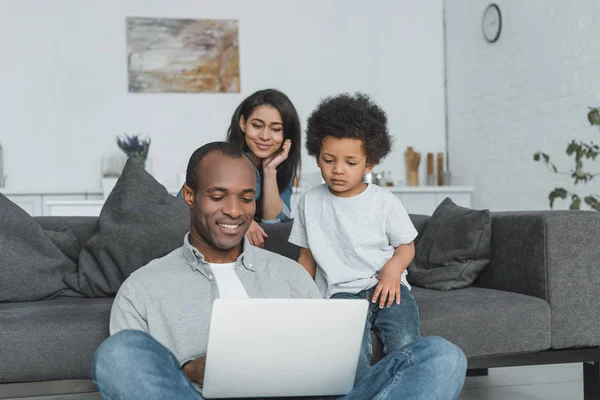 Afro-américains parents et fils regardant ordinateur portable dans le salon — Photo de stock