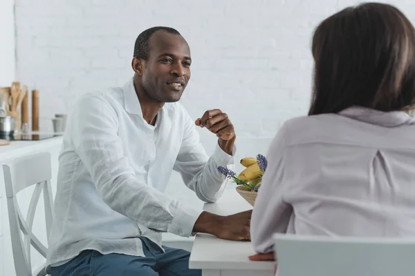 Afroamericana novia y novio hablando durante el desayuno en casa - foto de stock