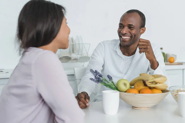 Novia afroamericana y novio sentado en la mesa durante el desayuno - foto de stock