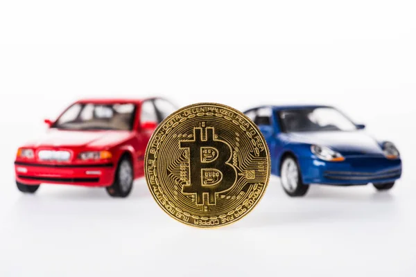 Зменшеному вигляді bitcoin і автомобіль моделей на білому — стокове фото
