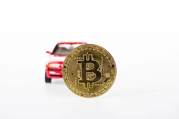 Vista de cerca de bitcoin y coche rojo aislado en blanco - foto de stock