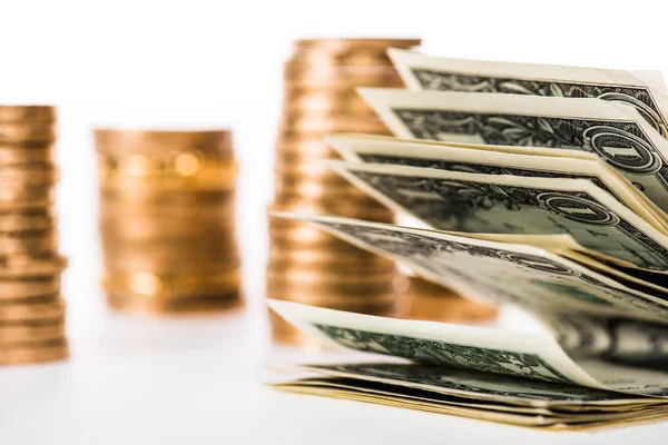 Close-up view of dollar banknotes and golden coins isolated on white — Stock Photo