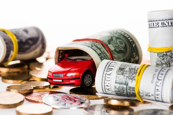 Close-up view of rolled dollar banknotes, small red car model and bitcoins isolated on white — Stock Photo