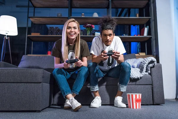 Lächelndes multiethnisches Paar beim gemeinsamen Videospiel zu Hause — Stockfoto