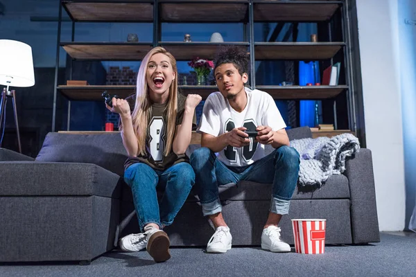Junges multiethnisches Paar beim gemeinsamen Videospiel zu Hause — Stockfoto