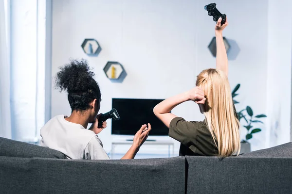 Back view of multiethnic couple playing video game together at home — Stock Photo