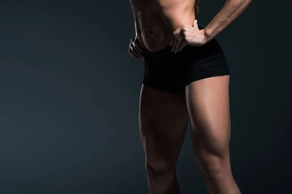 Vista cortada de pernas fisiculturistas do sexo feminino, isolado em cinza — Fotografia de Stock