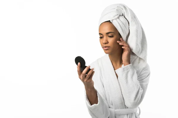 Mujer afroamericana en albornoz y toalla mirando al espejo, aislada en blanco - foto de stock