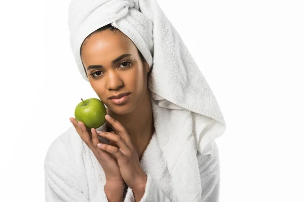 Hermosa mujer afroamericana en toalla posando con manzana, aislada en blanco - foto de stock