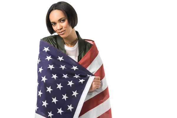 Sorridente menina afro-americana envolto em bandeira dos Estados Unidos, isolado em branco — Fotografia de Stock