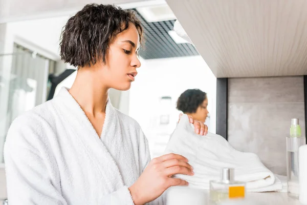 Belle fille afro-américaine en peignoir prenant serviette dans la salle de bain — Photo de stock