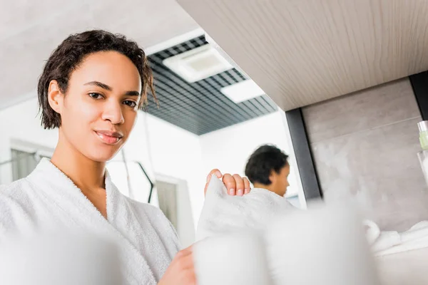 Hermosa africana americana chica tomando toalla en cuarto de baño - foto de stock