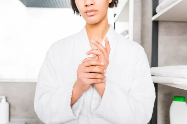 Обрезанный вид на африканскую американку в халате, стоящую в ванной — стоковое фото