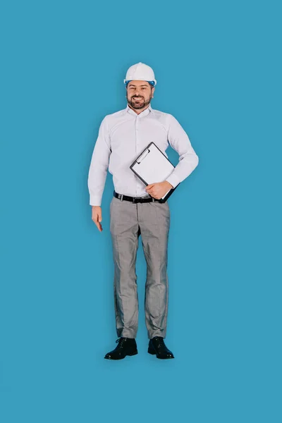 Vue de dessus du constructeur masculin dans le casque avec presse-papiers isolé sur fond bleu — Photo de stock